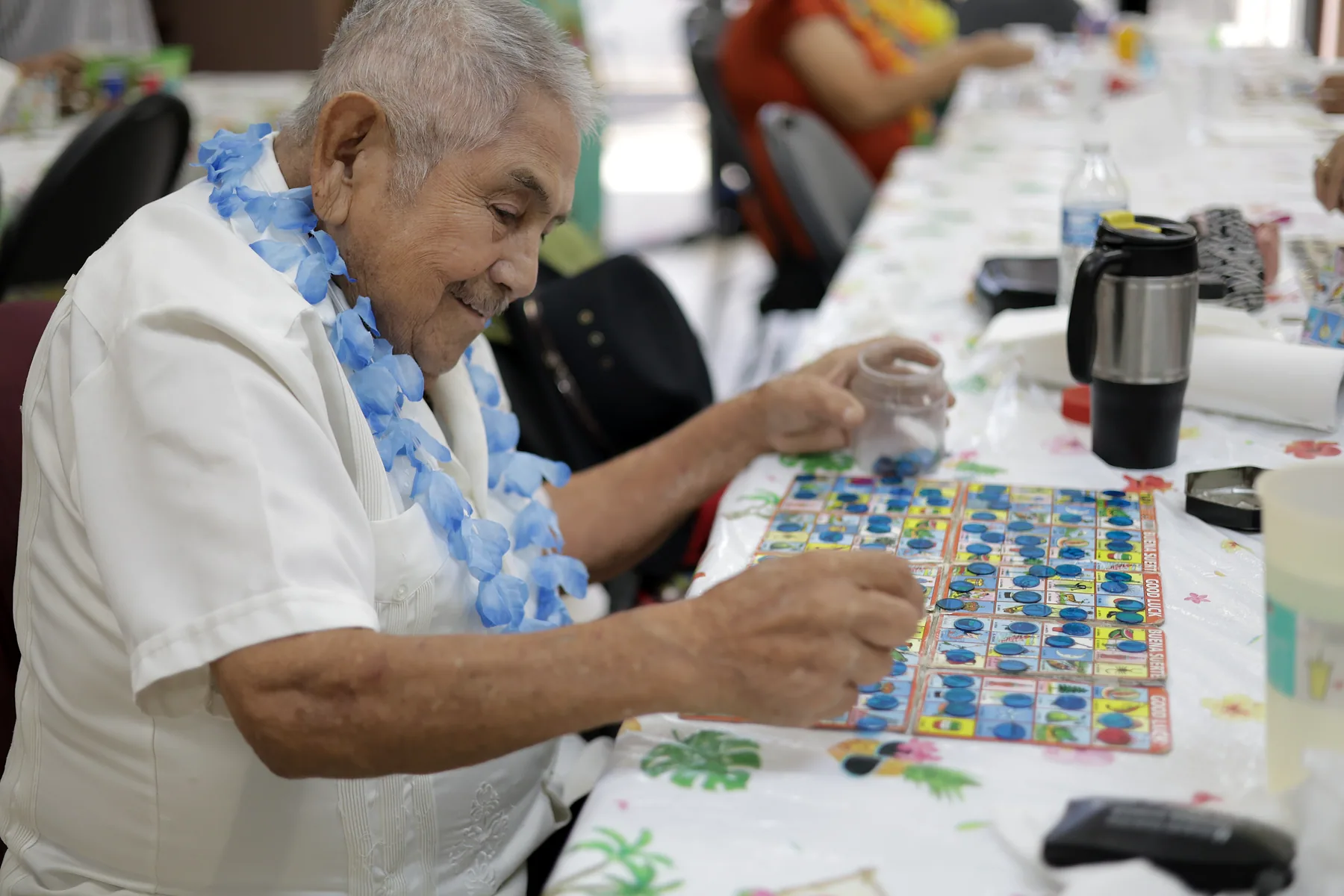 A participant smiling as he marks his lotería board